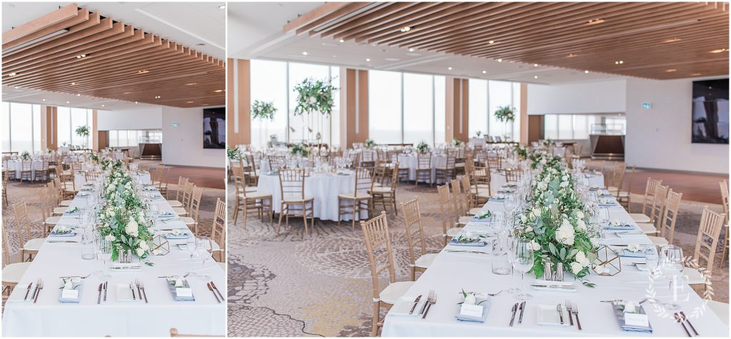Reception setup at TwentyTwo at the Westin, featuring long and round tables with white linens, greenery centerpieces, gold chiavari chairs, and a wood-slatted ceiling with floor-to-ceiling windows.