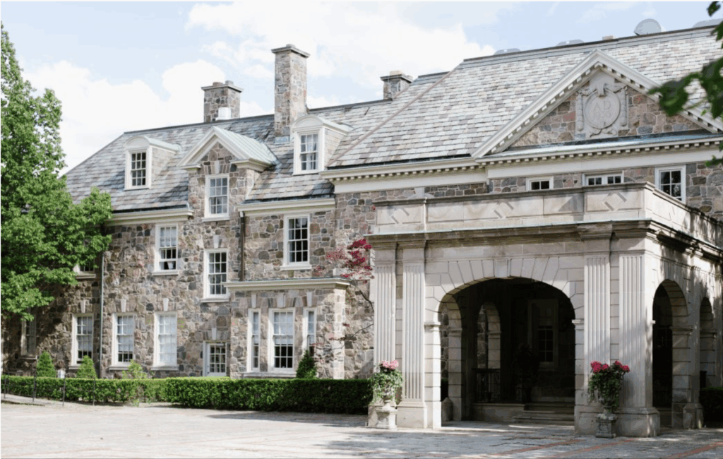 Elegant stone manor with arched stone portico and manicured hedges, Graydon Hall Manor (Toronto), a classic Old World European wedding venue in Canada.