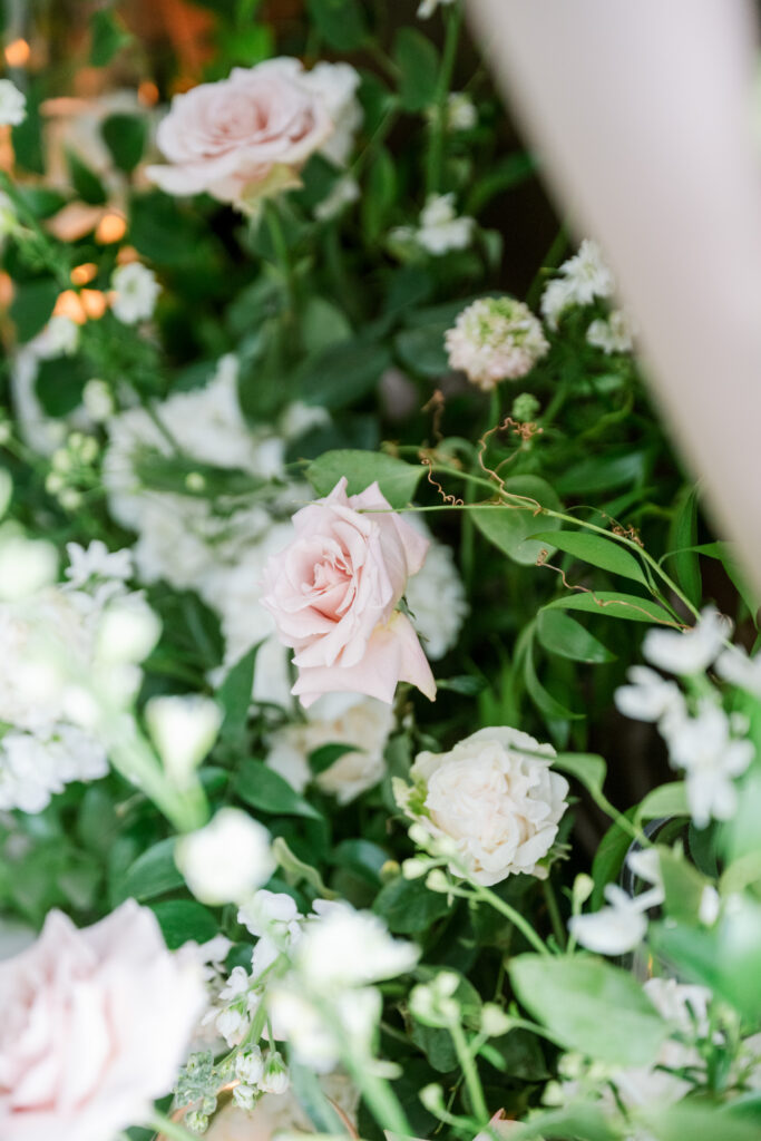 Close-up of a lush blush and white rose garland with greenery, styled by Amanda Simplice.