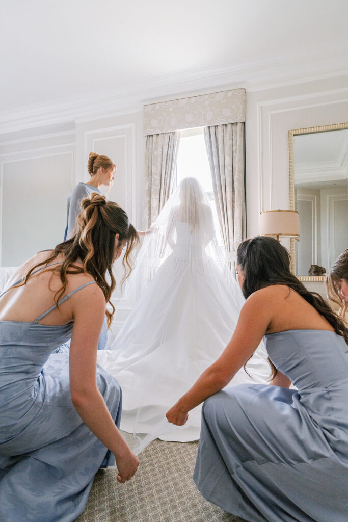 Bride getting ready with her bridesmaids in a suite at the Fairmont Château Laurier, Ottawa —
wedding photography by Emma Haidar