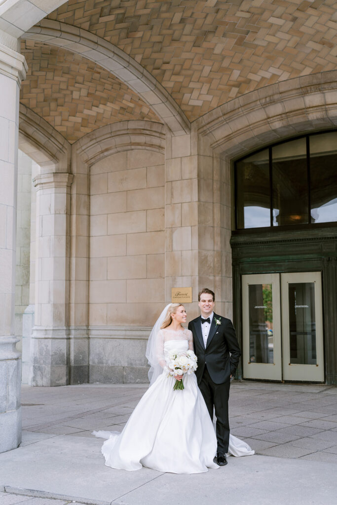 Wedding portrait against the limestone exterior of the Fairmont Château Laurier, Ottawa — photographed by Emma Haidar